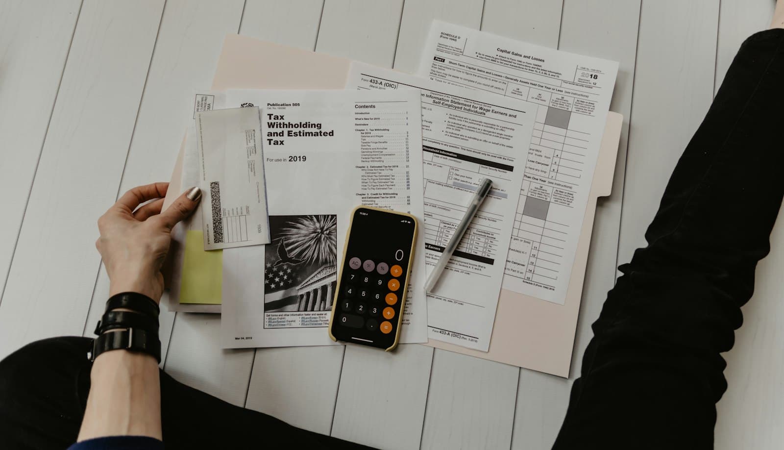 Tax forms, a calculator, and a pen on a desk — the back office is where the quiet, boring, renewable agents live