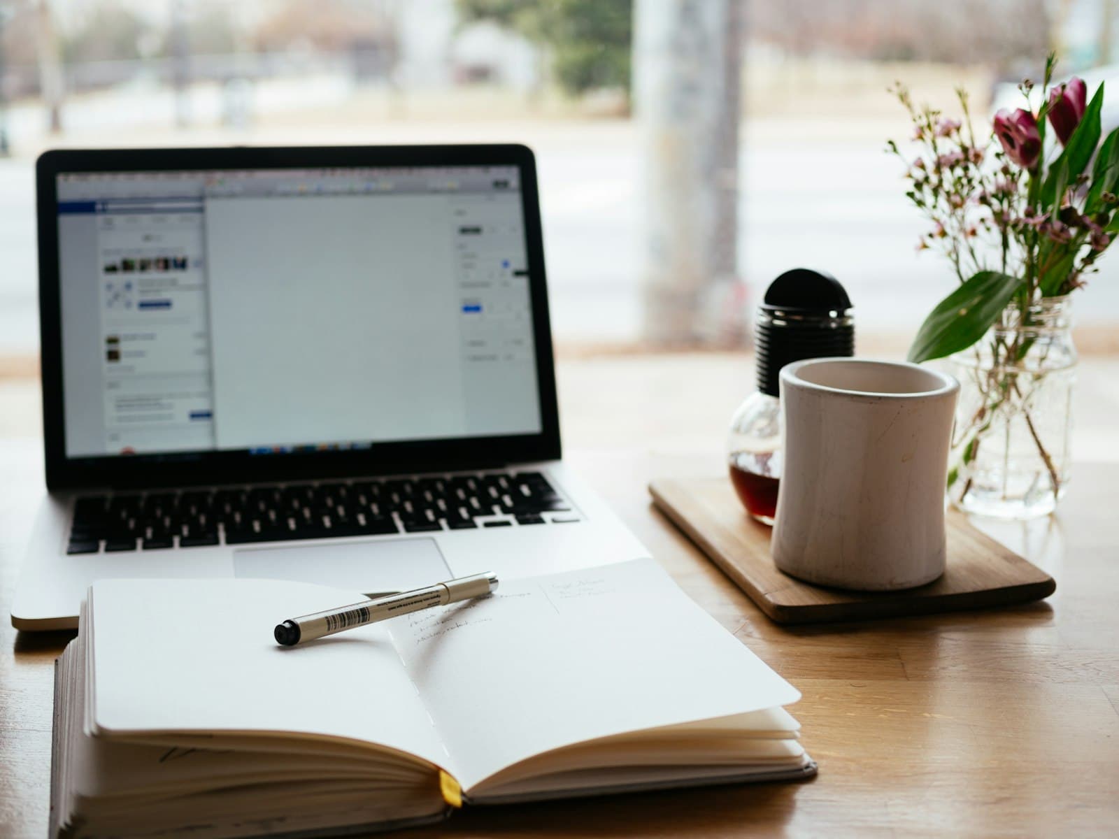 A laptop and an open notebook on a desk — the curriculum is the easy part; the coaching is what you are paying for