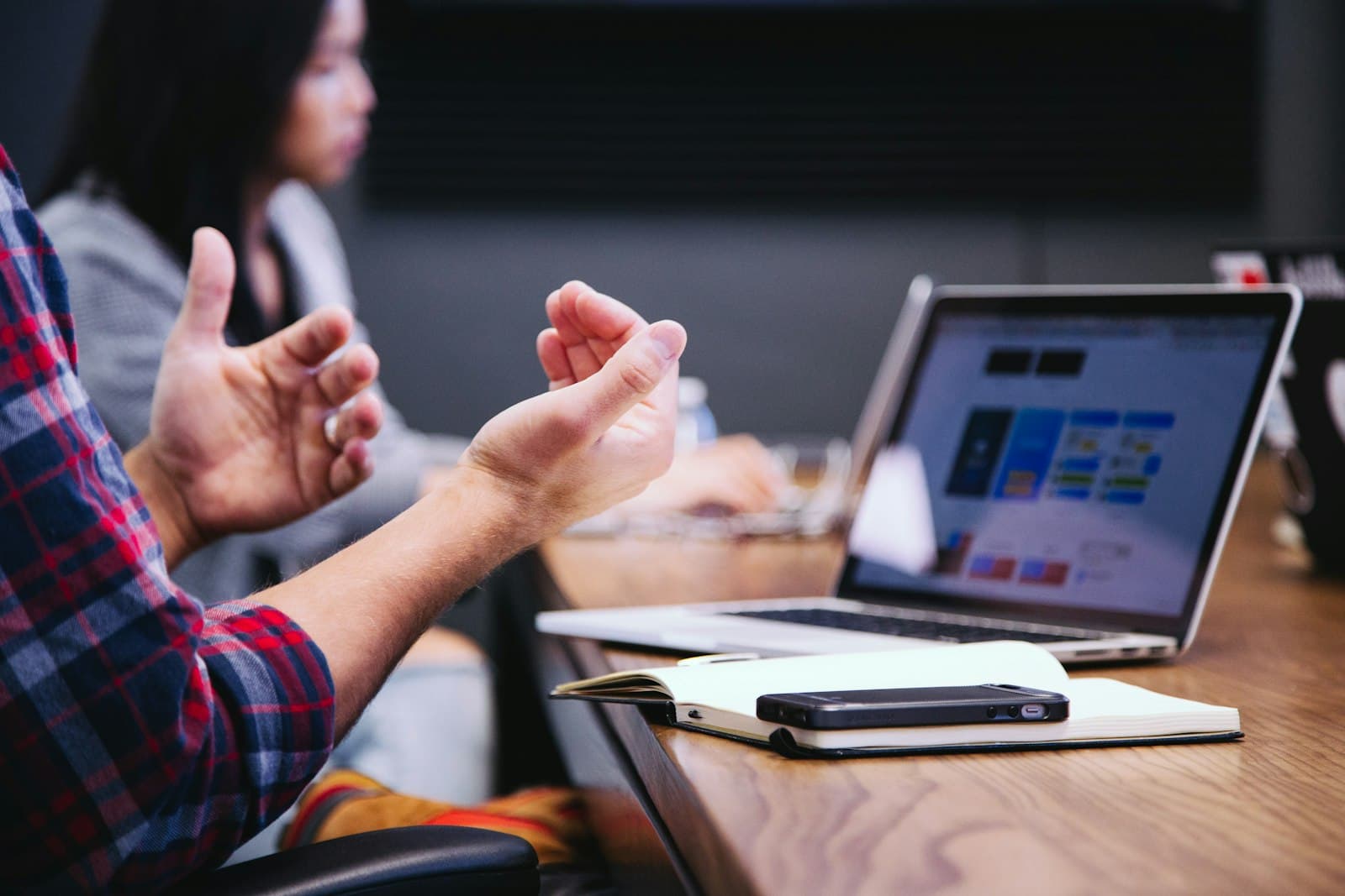 Someone explaining a point across a laptop in a working session — live coaching is the part a recording cannot replace